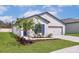 Well-maintained home featuring a manicured lawn, blue shutters, and a two-car garage at 1786 White Elephant Loop, Winter Haven, FL 33884