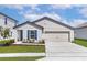 Charming single-story home with a two-car garage, manicured lawn, and bright blue window shutters at 1786 White Elephant Loop, Winter Haven, FL 33884