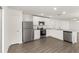 Modern kitchen with stainless steel appliances, white cabinetry, granite countertops, and wood-look floors at 1786 White Elephant Loop, Winter Haven, FL 33884