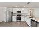 Well-equipped kitchen with stainless steel appliances, white cabinets, granite counters, and wood-look flooring at 1786 White Elephant Loop, Winter Haven, FL 33884