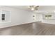 Spacious living room featuring wood-look floors, natural light, and seamless flow to the kitchen area at 1786 White Elephant Loop, Winter Haven, FL 33884