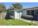 Rear exterior view of the home with an enclosed patio area and overgrown landscaping at 1122 E Edgewood Dr, Lakeland, FL 33803
