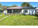 Front exterior of home with metal roof, overgrown foliage and unkempt lawn at 1122 E Edgewood Dr, Lakeland, FL 33803
