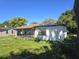 View of the exterior of home and overgrown front yard with metal roof at 1122 E Edgewood Dr, Lakeland, FL 33803