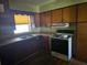 Kitchen with wooden cabinets, a double basin sink, and an electric stove at 1122 E Edgewood Dr, Lakeland, FL 33803