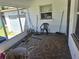 Enclosed patio with patterned flooring and a seating area with yard tools at 1122 E Edgewood Dr, Lakeland, FL 33803