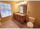 Well-lit bathroom features a double sink vanity with granite countertop and a large window at 15387 Avenue Of The Arbors, Winter Garden, FL 34787