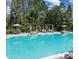 Community pool featuring lounge chairs, umbrellas and a pergola at 15387 Avenue Of The Arbors, Winter Garden, FL 34787
