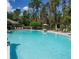 Large, clear swimming pool surrounded by lounge chairs and a lush tree line at 15387 Avenue Of The Arbors, Winter Garden, FL 34787