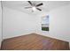 This bedroom has wood-look flooring, a ceiling fan and a window with a view to the outside at 25 Inconnu Dr, Kissimmee, FL 34759