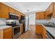 Efficient kitchen with wood cabinets and modern stainless steel appliances at 25 Inconnu Dr, Kissimmee, FL 34759