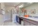 Modern bathroom featuring a double vanity, granite countertop, glass-enclosed shower, and neutral tile flooring at 4117 Jespersen St, Apopka, FL 32712