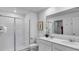 Bathroom with a double sink vanity, a glass-enclosed shower, and a large mirror at 510 Puma Loop, Groveland, FL 34736