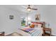 Bright bedroom with colorful decor, a plush bed, and a large window overlooking the street at 510 Puma Loop, Groveland, FL 34736