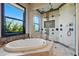 Luxury bathroom with a standalone soaking tub and glass enclosed shower featuring dual shower heads and body jets at 7769 Summerlake Pointe Blvd, Winter Garden, FL 34787