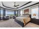 Luxurious primary bedroom features a tray ceiling, large windows, and comfortable seating area at 7769 Summerlake Pointe Blvd, Winter Garden, FL 34787