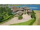 A luxurious estate boasts elegant stone accents, a circular driveway, and meticulously manicured landscaping at 7769 Summerlake Pointe Blvd, Winter Garden, FL 34787