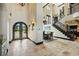 A grand foyer features an iron-wrought entry door, staircase, and access to the formal dining room at 7769 Summerlake Pointe Blvd, Winter Garden, FL 34787