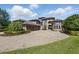 A circular driveway leads to the stately home featuring stone accents and a barrel tile roof at 7769 Summerlake Pointe Blvd, Winter Garden, FL 34787