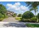 Front yard showcases the home's exterior, lush landscaping, and a winding paved driveway at 7769 Summerlake Pointe Blvd, Winter Garden, FL 34787