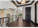 Open hallway with dark hardwood floors leads to a view of the waterfront from large glass doors at 7769 Summerlake Pointe Blvd, Winter Garden, FL 34787