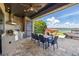 View of the outdoor kitchen area with a grill, dining set, and tranquil lake views at 7769 Summerlake Pointe Blvd, Winter Garden, FL 34787