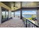 A covered patio with stone floors overlooks a beautiful lake view, complete with elegant wrought iron railings at 7769 Summerlake Pointe Blvd, Winter Garden, FL 34787