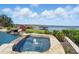 Resort-style pool and spa with waterfall feature overlooks serene lake views and lush landscaping at 7769 Summerlake Pointe Blvd, Winter Garden, FL 34787