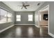 Well-lit bedroom with modern ceiling fan, two windows, and wood-look tile flooring at 108 Stanton Estates Cir, Winter Garden, FL 34787