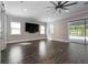 Bright living room with wood-look flooring, modern ceiling fan, and sliding glass doors to backyard at 108 Stanton Estates Cir, Winter Garden, FL 34787