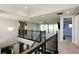 Open loft area with staircase and iron railing, leading to the living room with great natural light at 108 Stanton Estates Cir, Winter Garden, FL 34787