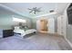 Spacious main bedroom with tray ceiling, carpet floors, and an ensuite bathroom with sliding barn doors at 108 Stanton Estates Cir, Winter Garden, FL 34787