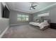 Spacious main bedroom with tray ceiling, carpet floors, and a view to the private outdoor space at 108 Stanton Estates Cir, Winter Garden, FL 34787