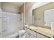 Bright bathroom featuring a shower with white tile surround, granite countertop and white cabinets at 130 Southern Pecan Cir # 205, Winter Garden, FL 34787