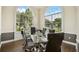 Elegant dining room featuring large windows, a glass table, and leather chairs at 130 Southern Pecan Cir # 205, Winter Garden, FL 34787