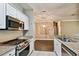 Contemporary kitchen featuring stainless steel appliances, stone countertops, and white cabinets at 130 Southern Pecan Cir # 205, Winter Garden, FL 34787