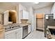 Well-lit kitchen featuring stainless steel appliances, granite countertops, and white cabinets at 130 Southern Pecan Cir # 205, Winter Garden, FL 34787