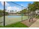 Community tennis courts surrounded by a black fence and greenery with benches at 130 Southern Pecan Cir # 205, Winter Garden, FL 34787