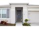 Welcoming front entrance with a gray door, sidelights, and neatly landscaped garden beds, providing great curb appeal at 1823 Pristine Loop, Lakeland, FL 33811