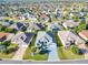 High-angle aerial view showing a home's landscaping and neighborhood featuring mature trees and well-kept lawns at 2518 Foxbridge Ter, The Villages, FL 32162