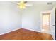 Bedroom featuring wood-look floors, neutral walls, ceiling fan, and doorway to the hall at 2518 Foxbridge Ter, The Villages, FL 32162