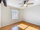 Bright bedroom featuring hardwood floors, a ceiling fan, and a window at 2518 Foxbridge Ter, The Villages, FL 32162