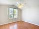 Cozy bedroom with hardwood floors, neutral walls, ceiling fan, and a sunlit window at 2518 Foxbridge Ter, The Villages, FL 32162