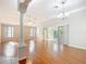 Spacious living room featuring wood flooring, fan, and sliding doors leading to the screened porch at 2518 Foxbridge Ter, The Villages, FL 32162