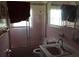 Bathroom features pink tile, bathtub with shower, mirror, sink, and toilet at 894 Superior St, Deltona, FL 32725