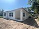 Exterior back of home featuring large windows, a covered porch, and a driveway at 3611 Chelsea St, Orlando, FL 32803