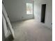 Unfinished bedroom with door lying against the wall and window view to the outside at 3611 Chelsea St, Orlando, FL 32803