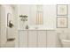 Modern bathroom featuring white cabinets, a large mirror, neutral color scheme, and clean lines at 530 Puma Loop, Groveland, FL 34736