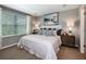 Relaxing main bedroom featuring a king-sized bed, soft carpet, a decorative art piece, and windows with natural light at 2545 Penguin Blvd, Davenport, FL 33837