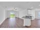 Open-concept living room with wood-look floors, ceiling fan and access to a large lawn at 2674 Sw 165Th Street Rd, Ocala, FL 34473